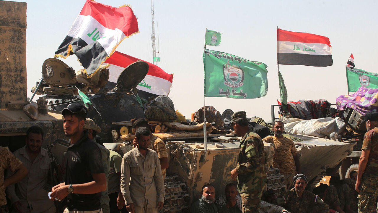 839861862 Fighters of Hashed Al-Shaabi (Popular Mobilization units) gather around the Tal Afar airport, west of Mosul, as they and Iraqi forces backed by local militia and a US-led coalition advance in driving the Islamic State group from the city, on August 27, 2017.
Just a week after authorities announced an offensive to push the jihadists from one of their last major urban strongholds in Iraq, the Joint Operations Command said Iraqi forces held all 29 districts of the city and were pursuing final mopping up opera