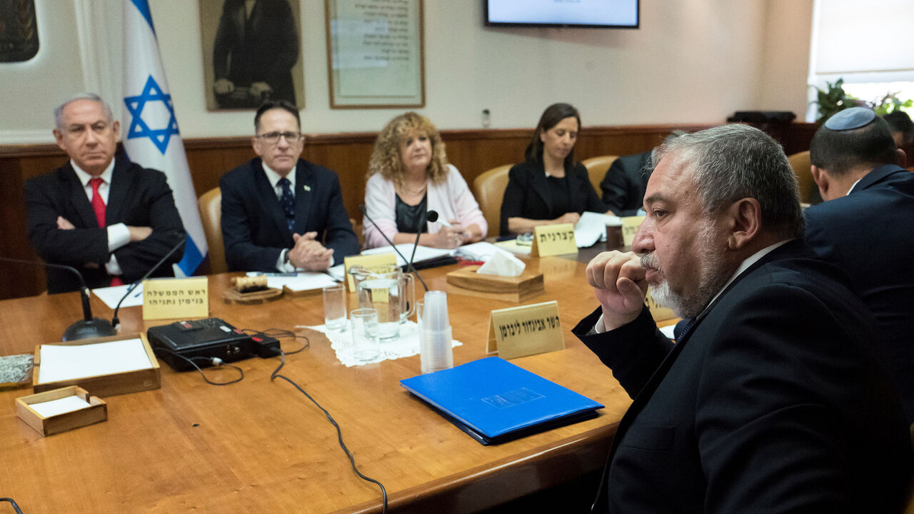 ISRAEL-POLITICS/ Israeli Defence Minister Avigdor Lieberman (R) sits opposite of Israeli Prime Minister Benjamin Netanyahu and Israeli Cabinet Secretary Tzachi Braverman during the weekly cabinet meeting at the prime minister's office in Jerusalem, June 10, 2018. Jim Hollander/Pool via Reuters - RC13DBD58690
