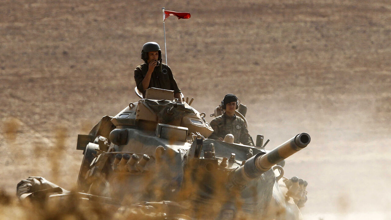 457152670 SANLIURFA, TURKEY - OCTOBER 13: (TURKEY OUT) Turkish soldiers hold their position on a tank as they watch the town of Kobani from near the Mursitpinar border crossing, on the Turkish-Syrian border in the southeastern town of Suruc in Sanliurfa province October 13, 2014. The strategic border town of Kobani has been beseiged by Islamic State militants since mid-September forcing more than 200,000 people to flee into Turkey. (Photo by Gokhan Sahin/Getty Images)