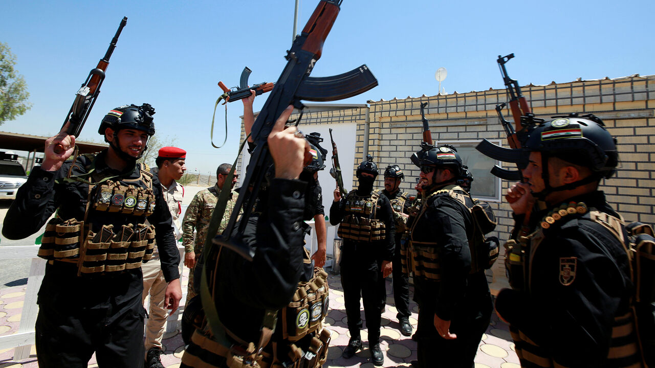 USA-IRAN/IRAQ Members of Iraqi Popular Mobilization Forces (PMF) carry their weapons as they shout slogans at their headquarters in the holy city of Najaf, Iraq July 2, 2019. REUTERS/Alaa Al-Marjani - RC1F77CF3350