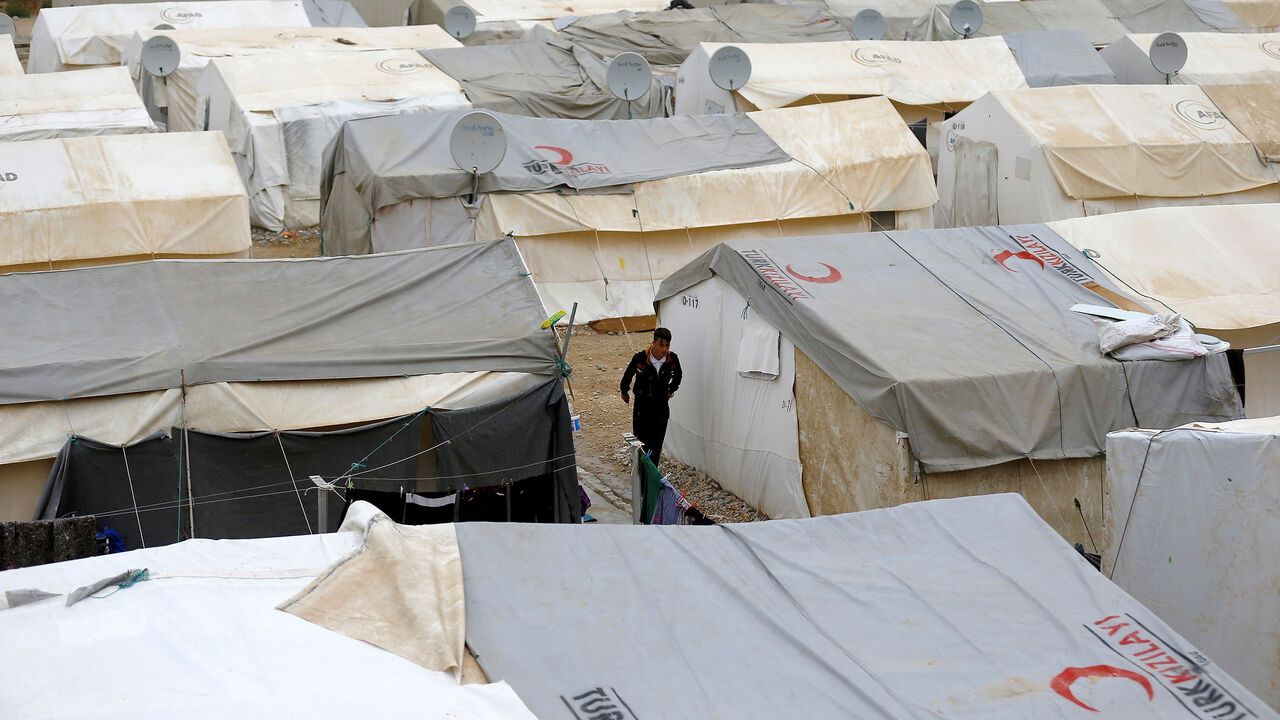 TURKEY-EUROPE/REFUGEES A Syrian refugee man walks between tents in Nizip refugee camp, near the Turkish-Syrian border in Gaziantep province, Turkey, November 30, 2016. REUTERS/Umit Bektas - RC1D41DB2700