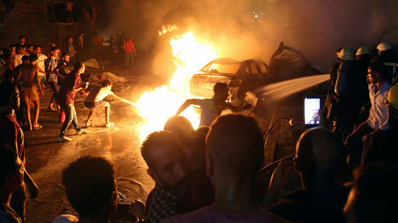People extinguish a fire from a blast outside the National Cancer Institute, Cairo People extinguish a fire from a blast outside the National Cancer Institute, Cairo, Egypt August 4, 2019. REUTERS/Shokry Hussien TPX IMAGES OF THE DAY - RC1F2E7214D0