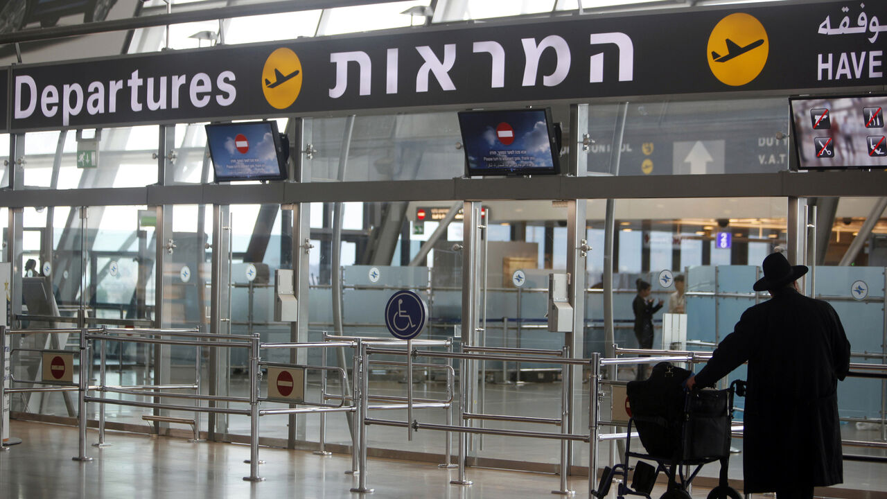 A passenger stands in the departure hall at Israel's Ben-Gurion International Airport near Tel Aviv, during a strike by airline workers, April 22, 2013. Israel's cabinet on Sunday approved an open skies agreement to boost airline traffic to and from Europe, defying a strike by workers at El Al and two smaller airlines who fear the greater competition with foreign airlines will cost them jobs. REUTERS/Nir Elias (ISRAEL - Tags: POLITICS TRANSPORT BUSINESS EMPLOYMENT CIVIL UNREST) - GM1E94M17SC01