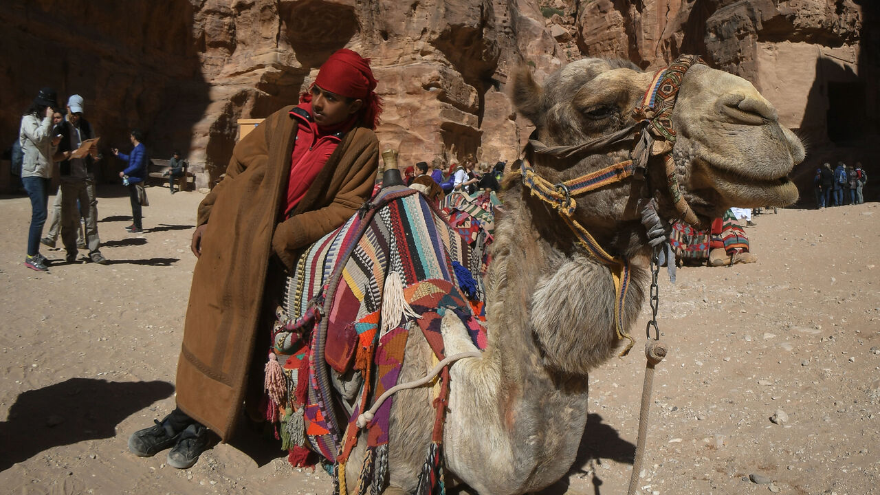 1125671913 A member of Al B'doul, a Bedouin tribe with his camel awaiting for tourists outside Petra's most elaborate ruin, Al Khazneh (the Treasury).
On Saturday, February 10, 2019, in Petra, Ma'an Governorate, Jordan. (Photo by Artur Widak/NurPhoto via Getty Images)