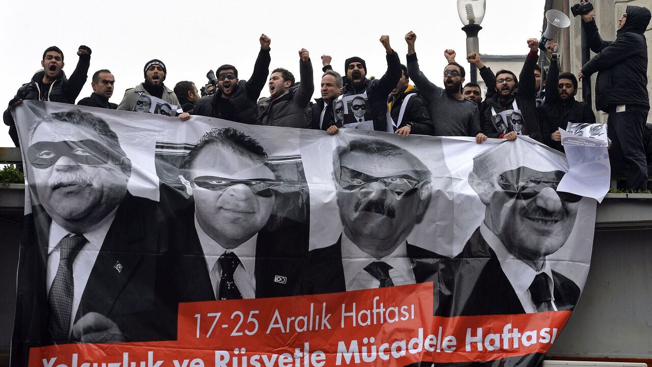 TURKEY-PROTEST/ Supporters of main opposition Republican People's Party (CHP) hold a banner with pictures of four former ministers while shouting anti-government slogans during a protest in Ankara December 17, 2014. Main opposition CHP held an anti-government protest in Ankara on the first anniversary of the corruption probe, which became public with police raids on Dec. 17 last year, leading to the resignation of three ministers and prompted Erdogan to purge the state apparatus, reassigning thousands of police and hundred