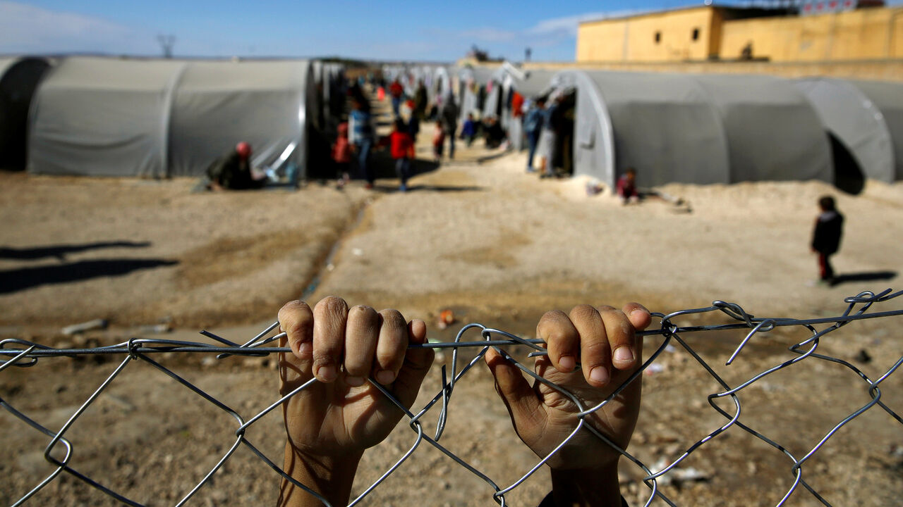 PEOPLE-BEHRAKIS/ FILE PHOTO: A Kurdish refugee boy from the Syrian town of Kobani holds onto a fence that surrounds a refugee camp in the border town of Suruc, Sanliurfa province, November 3, 2014. REUTERS/Yannis Behrakis/File photo SEARCH "YANNIS BEHRAKIS" FOR THIS STORY. SEARCH "WIDER IMAGE" FOR ALL STORIES. - RC190D47D5F0