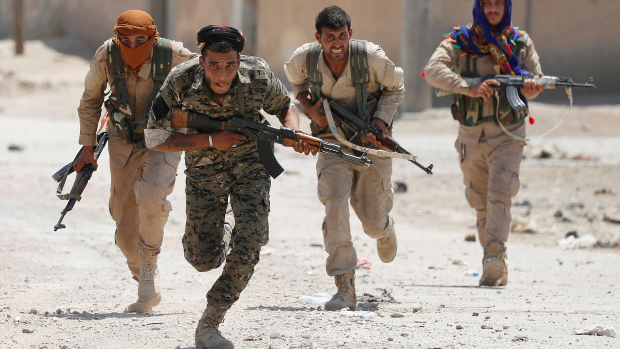 MIDEAST-CRISIS/SYRIA-RAQQA Kurdish fighters from the People's Protection Units (YPG) run across a street in Raqqa, Syria July 3, 2017. REUTERS/Goran Tomasevic TPX IMAGES OF THE DAY - RC1F9D39A050