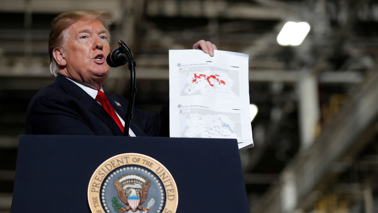 USA-TRUMP/ U.S. President Donald Trump shows maps of Syria and Iraq depicting the size of the "ISIS physical caliphate" as he speaks to workers while touring the Lima Army Tank Plant (LATP) Joint Systems Manufacturing Center, the country's only remaining tank manufacturing plant, in Lima, Ohio, U.S., March 20, 2019. REUTERS/Carlos Barria - RC139DF142F0