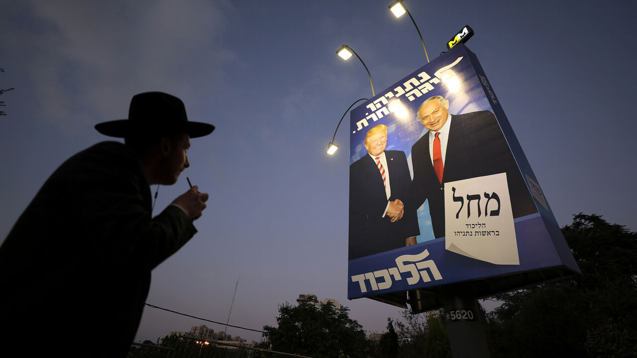 An ultra-Orthodox Jewish man walks past a Likud party election campaign banner depicting Israeli Prime Minister Benjamin Netanyahu and U.S. President Donald Trump in Jerusalem September 11, 2019. REUTERS/Ammar Awad - RC18D246D580