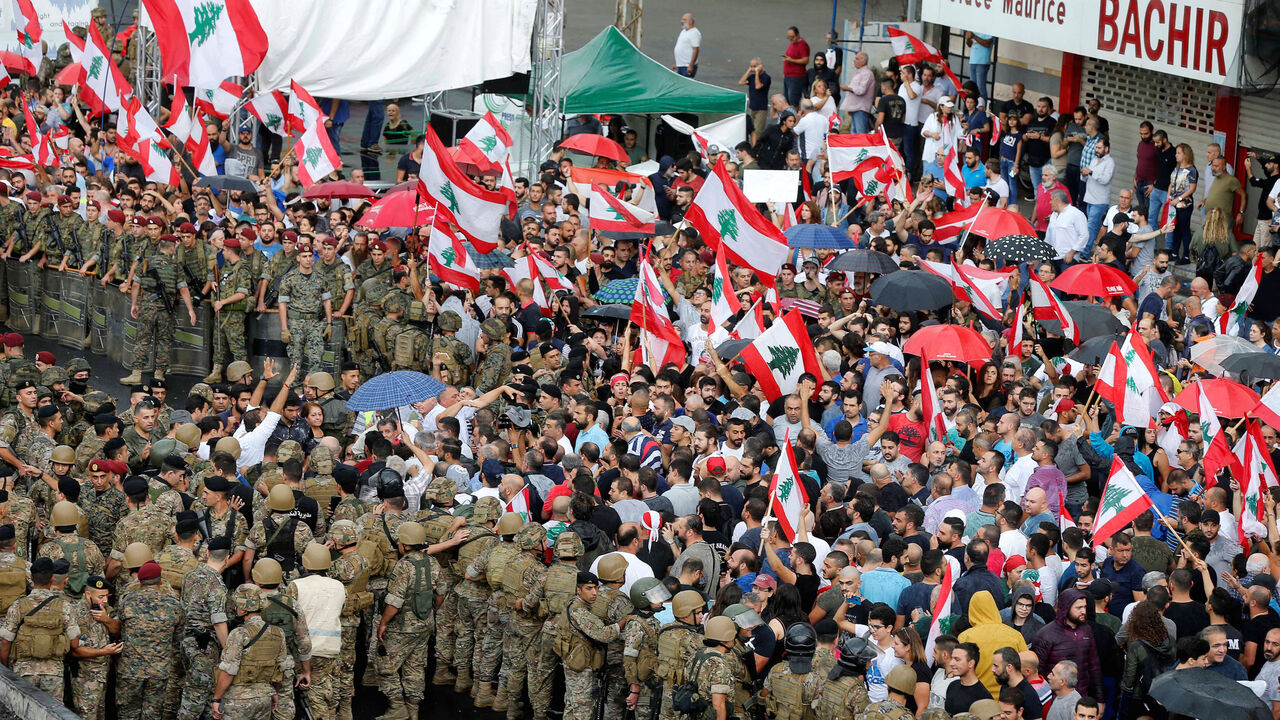 LEBANON-PROTESTS/ Demonstrators carry Lebanese flags during ongoing anti-government protests at a highway in Jal el-Dib, Lebanon October 23, 2019. REUTERS/Mohamed Azakir - RC16EC6EC900