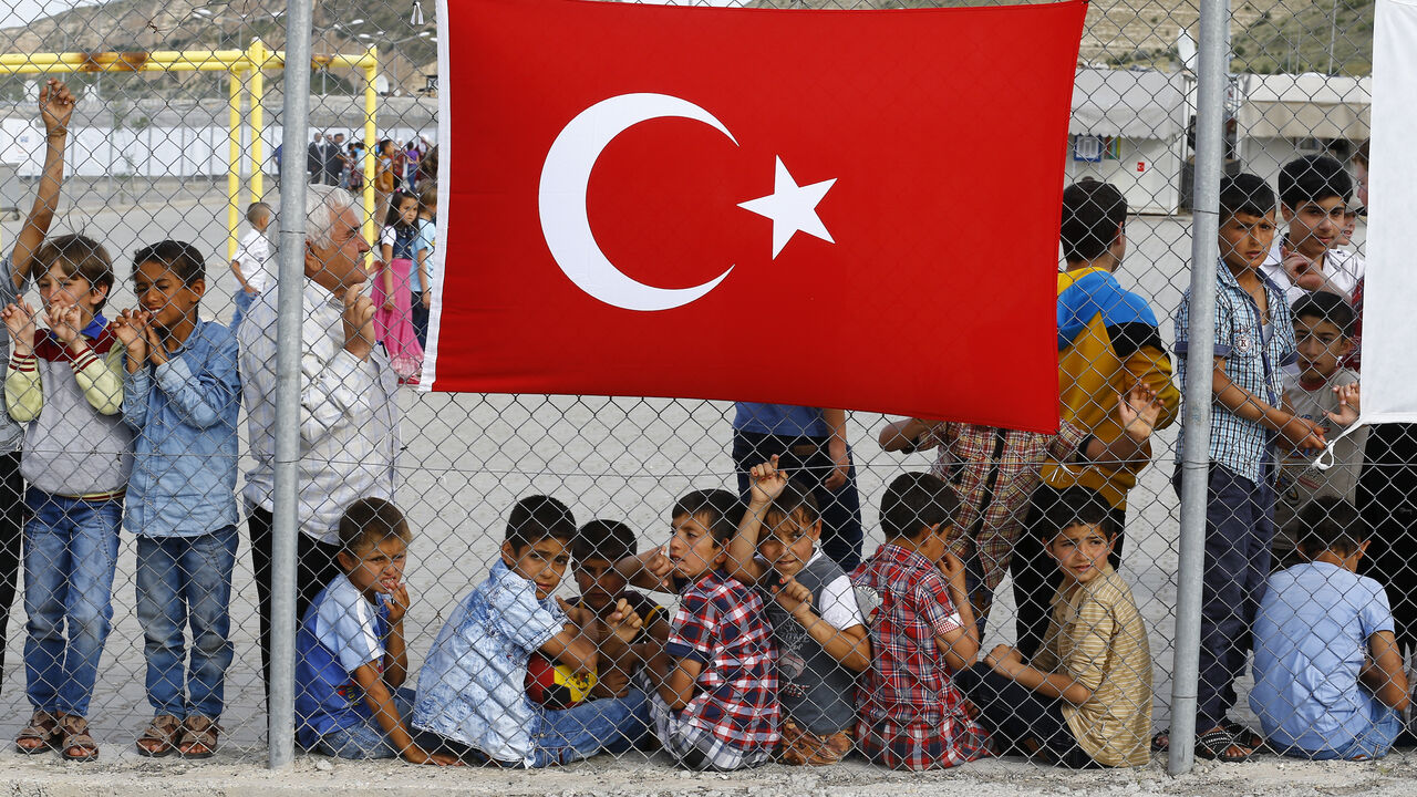 EUROPE-MIGRANTS/TURKEY-GERMANY An elderly refugee man stands with children as they wait for the arrival of German Chancellor Angela Merkel, Turkish Prime Minister Ahmet Davutoglu, EU Council President Donald Tusk and European Commission Vice-President Frans Timmermans (all not pictured) at Nizip refugee camp near Gaziantep, Turkey, April 23, 2016. REUTERS/Umit Bektas - LR1EC4N14M2B0