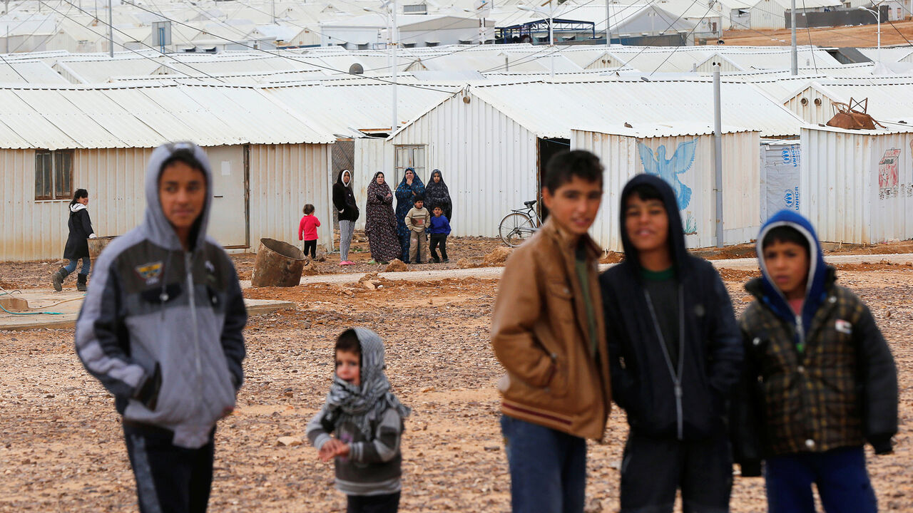 JORDAN-REFUGEES/ Syrian refugees look at the camera as they stand in front of their homes at Azraq refugee camp, near Al Azraq city, Jordan, December 8, 2018. REUTERS/Muhammad Ham - RC1ACC4C9FD0