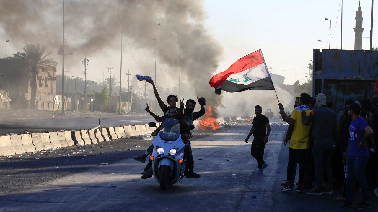IRAQ-PROTESTS/ Demonstrators gesture as they ride a motorcycle at a protest during a curfew, three days after the nationwide anti-government protests turned violent, in Baghdad, Iraq October 4, 2019. REUTERS/Alaa al-Marjani - RC1FD3EDB600