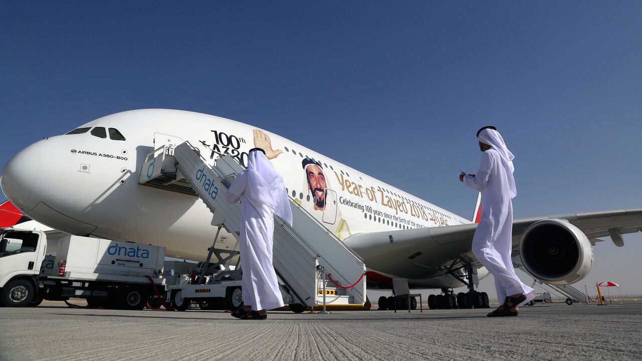 EMIRATES-AIRSHOW/ Visitors walk next to an Airbus A380, showing a picture of United Arab Emirates's Former President Sheikh Zayed bin Sultan al-Nahayan during the Dubai Airshow in Dubai, United Arab Emirates November 13, 2017. REUTERS/Satish Kumar - RC131063B650
