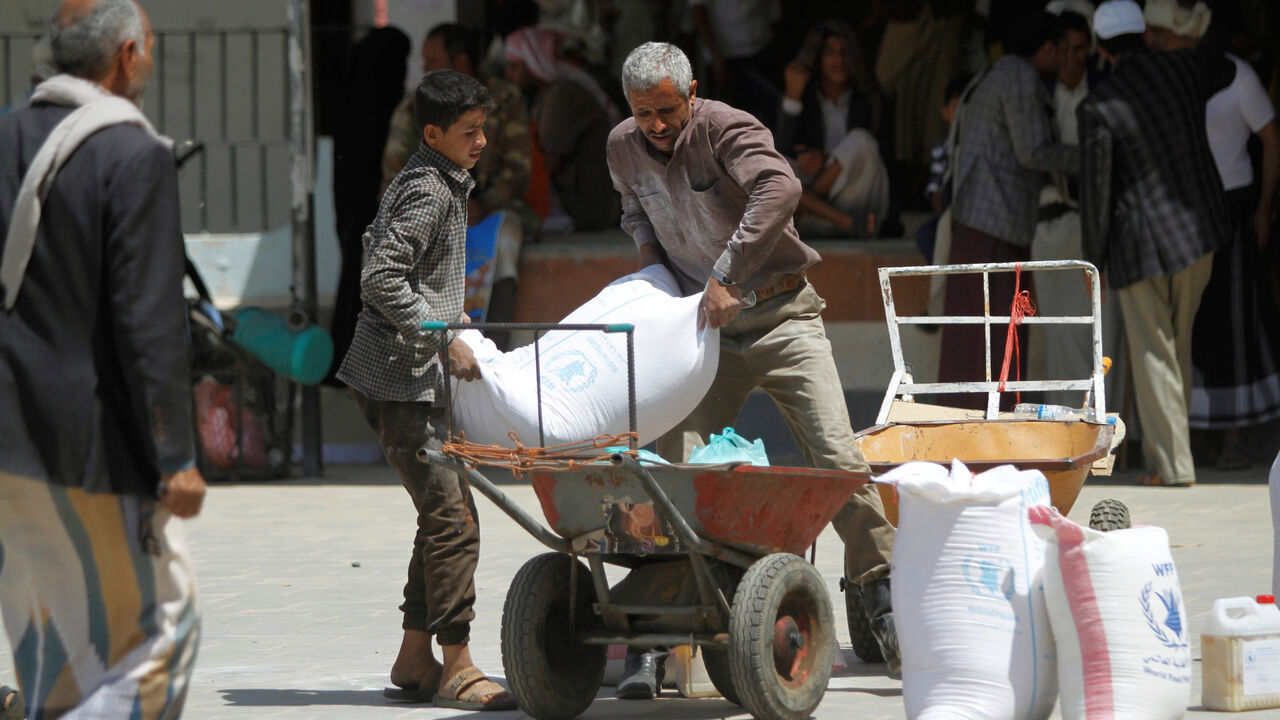 YEMEN-SECURITY/AID Workers carry the aid provided by the World Food Programme (WFP) for distribution in Sanaa, Yemen August 21, 2019. REUTERS/Mohamed al-Sayaghi - RC1E3E8CE770