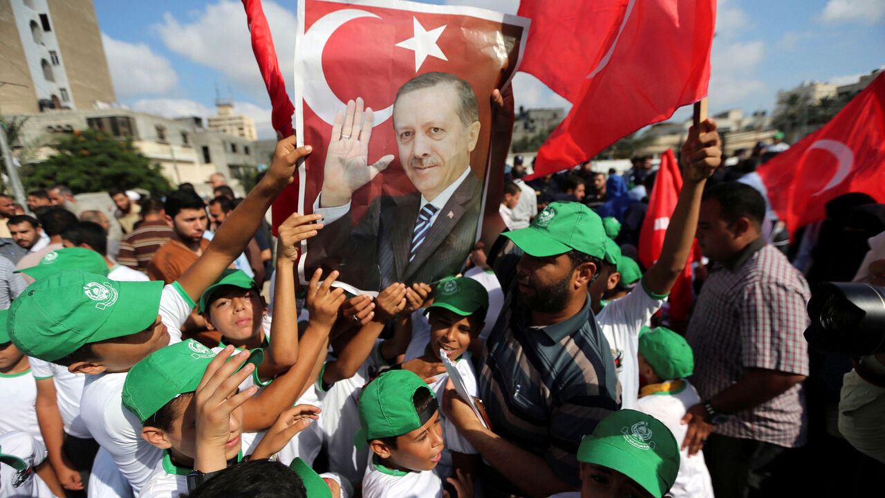 TURKEY-SECURITY/REACTION Palestinians hold a poster of Turkish President Tayyip Erdogan during a Hamas rally in support of Erdogan's government against a coup attempt, in Khan Younis in the southern Gaza Strip July 16, 2016. REUTERS/Ibraheem Abu Mustafa TPX IMAGES OF THE DAY - S1AETPWJGAAA