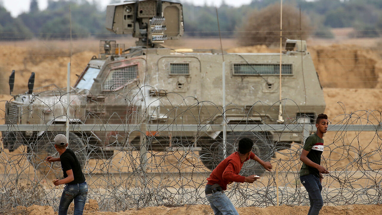ISRAEL-PALESTINIANS/PROTESTS Palestinian demonstrators hurl stones at Israeli troops during an anti-Israel protest at the Israel-Gaza border fence in the southern Gaza Strip October 25, 2019. REUTERS/Ibraheem Abu Mustafa - RC1C46E0D630
