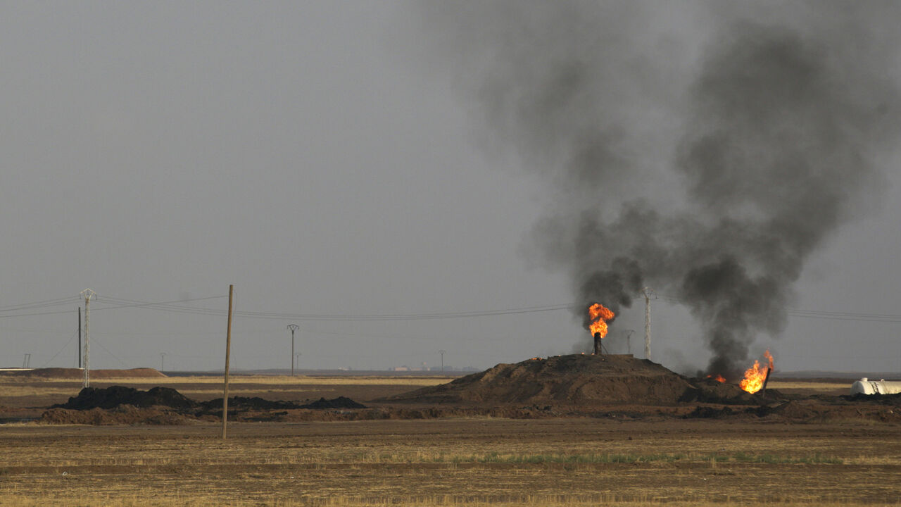 SYRIA-CRISIS/KURDS Smoke rises from an oil field in Al-Rmelan, Qamshli province November 11, 2013. With a string of military gains across northeastern Syria, a Kurdish militia is solidifying a geographic and political presence in the war-torn country, posing a dilemma for regional powers. Long oppressed under Syrian President Bashar al-Assad and his father before him, Kurds view the civil war as an opportunity to gain the kind of autonomy enjoyed by their ethnic kin in neighbouring Iraq. Picture taken November 11, 2013. REUT