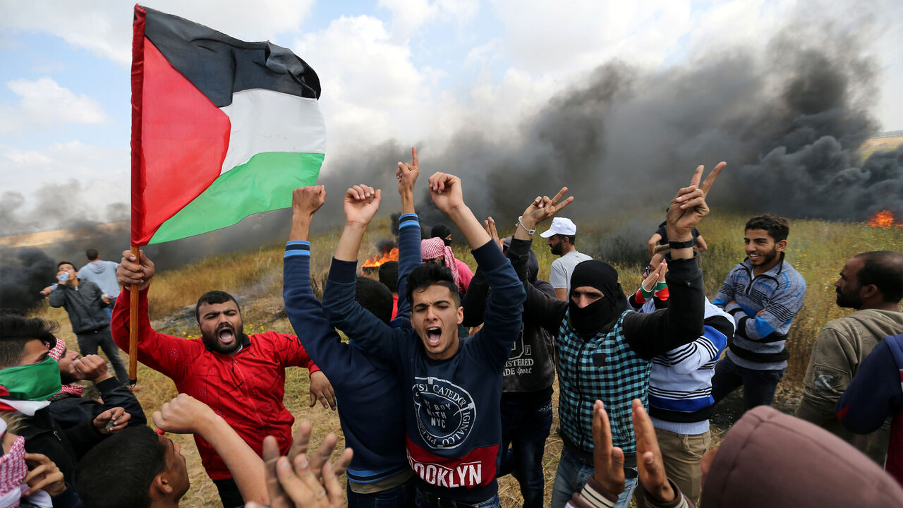 ISRAEL-PALESTINIANS/PROTESTS Palestinians shout during clashes with Israeli troops, during a tent city protest along the Israel border with Gaza, demanding the right to return to their homeland, the southern Gaza Strip March 30, 2018. REUTERS/Ibraheem Abu Mustafa - RC1AF1973D70