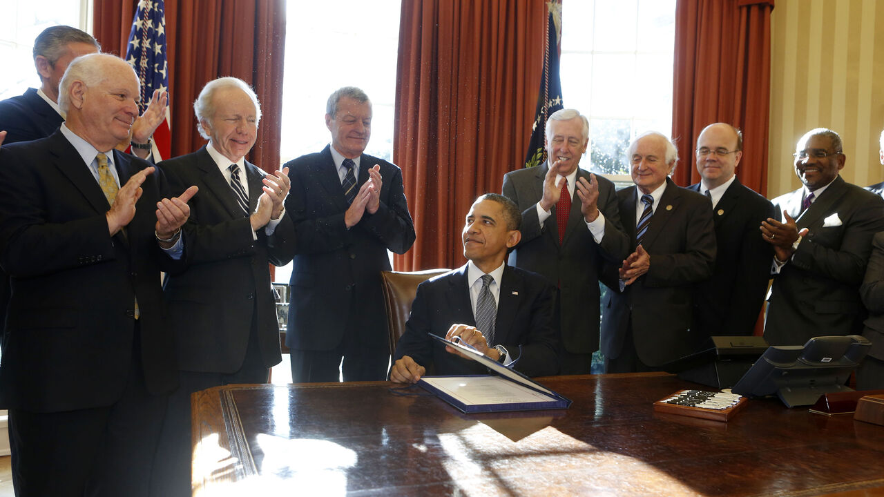 OBAMA/ U.S. President Barack Obama (seated) signs H.R. 6156, the Russia and Moldova Jackson-Vanik Repeal and Magnitsky Rule of Law Accountability Act, in the Oval Office of the White House in Washington, December 14, 2012. From L-R are: U.S. Sen. Ben Cardin, U.S. Sen. Joe Lieberman, U.S. Sen. Max Baucus, Obama, U.S. Rep. Steny Hoyer, U.S. Rep. Sandy Levin, U.S. Rep. Jim McGovern, and U.S. Rep. Gregory Meeks. REUTERS/Larry Downing (UNITED STATES - Tags: POLITICS) - GM1E8CF053K01