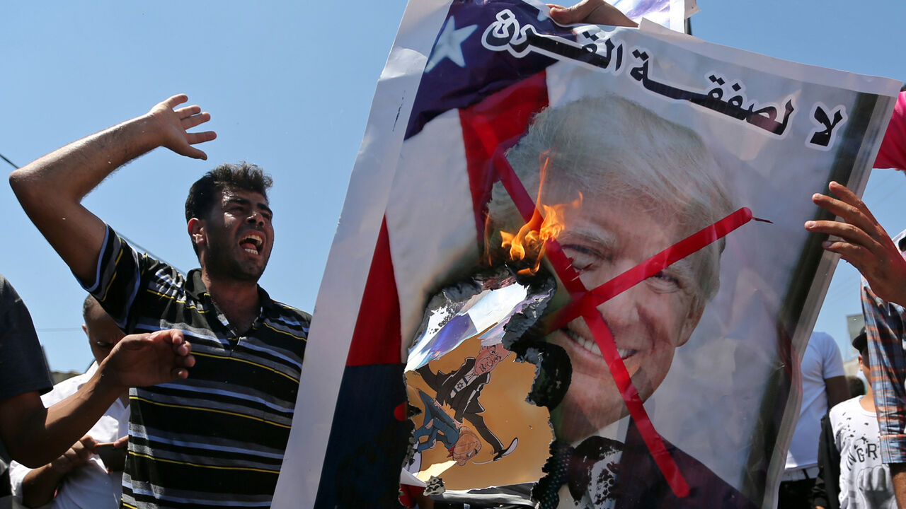 ISRAEL-PALESTINIANS/PLAN-PROTESTS Palestinian demonstrators burn a crossed-out poster depicting U.S. President Donald Trump and reading: "no for Deal of the Century" during a protest against Bahrain's workshop for U.S. Middle East peace plan, in the southern Gaza Strip, June 26, 2019. REUTERS/Ibraheem Abu Mustafa - RC1478E53560