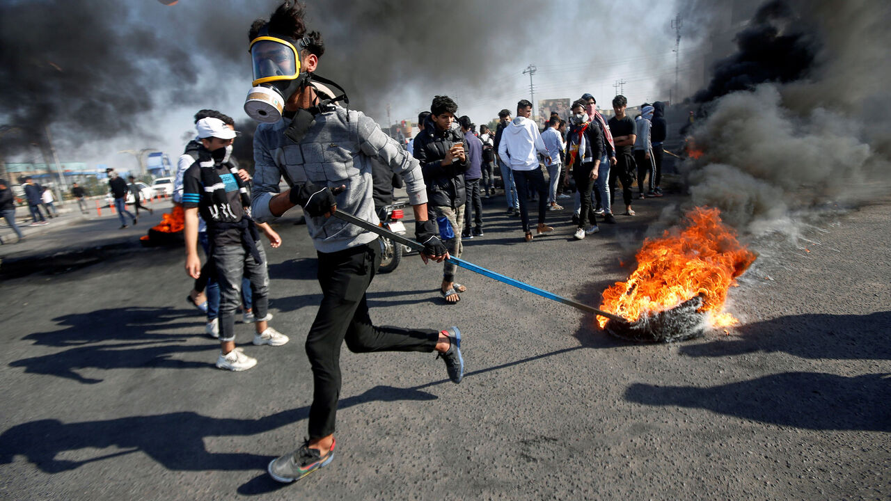 IRAQ-PROTESTS/ An Iraqi demonstrator pulls a burning tire during ongoing anti-government protests in Basra, Iraq January 20, 2020. REUTERS/Essam al-Sudani - RC2LJE9YYT3G
