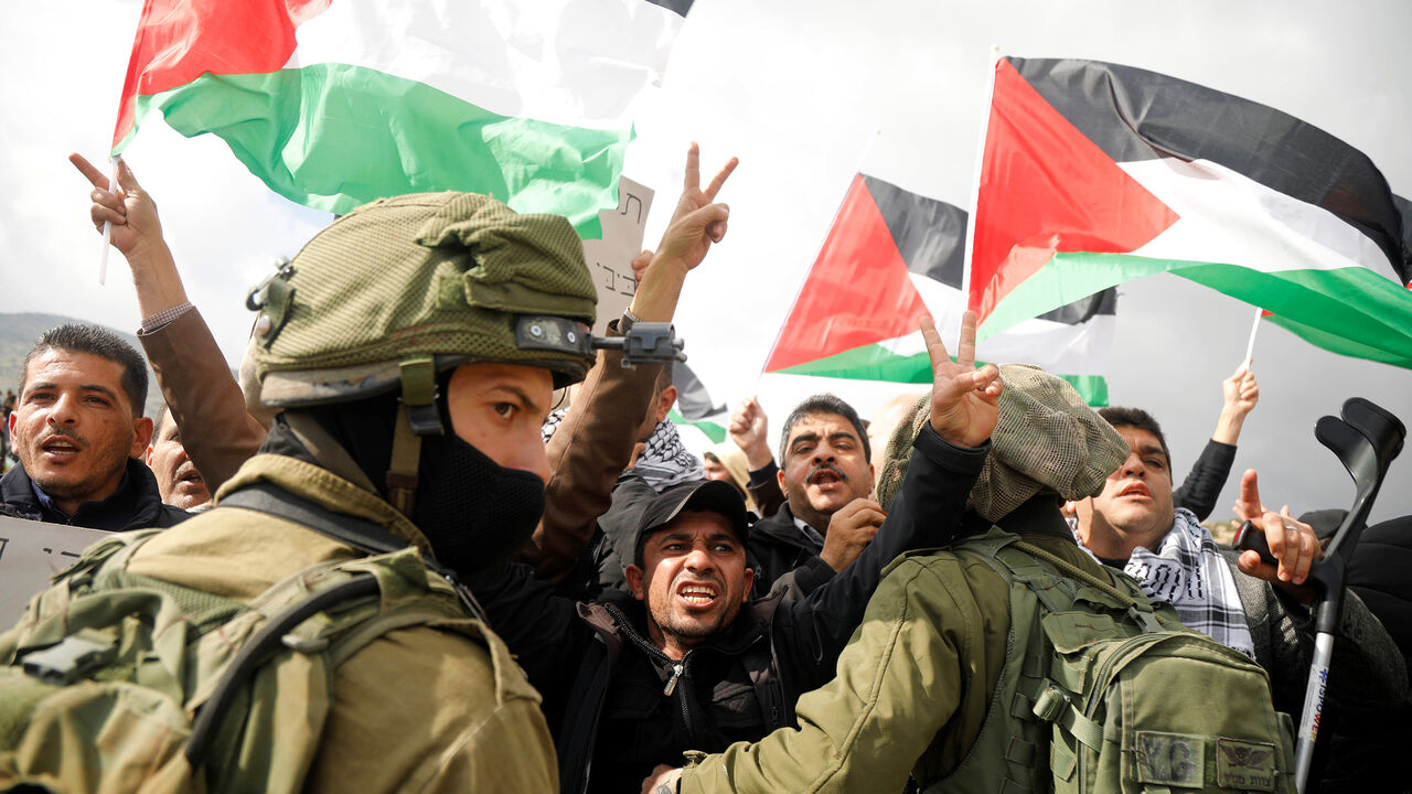 Palestinian demonstrators gesture in front of Israeli forces during a protest against the U.S. president Donald Trump’s Middle East peace plan, in Jordan Valley in the Israeli-occupied West Bank January 29, 2020. REUTERS/Raneen Sawafta - RC2PPE9PRZMB