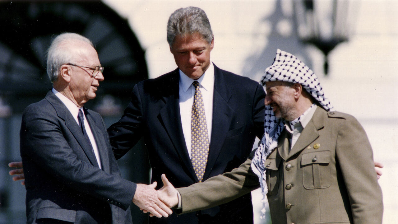 PLO Chairman Yasser Arafat (R) shakes hands with Israeli Prime Minister Yitzhak Rabin (L), as U.S. President Bill Clinton stands between them, after the signing of the Israeli-PLO peace accord, at the White House in Washington September 13, 1993. REUTERS/Gary Hershorn (UNITED STATES - Tags: POLITICS) - GM1E99D1UCD01