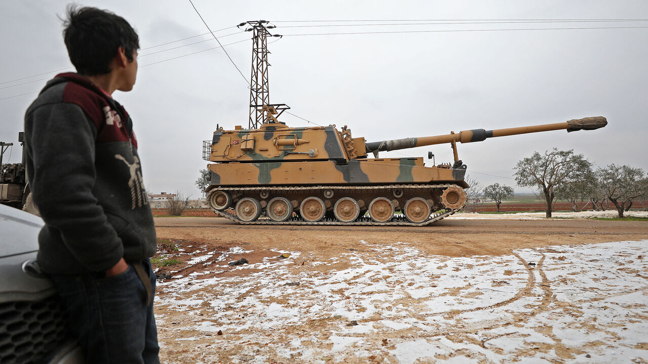 1200228211 A child gazes at a Turkish 155mm self-propelled artillery gun in the town of Binnish in Syrias northwestern province of Idlib, near the Syria-Turkey border on February 12, 2020. - Tensions escalated yesterday between Syria's regime and rebel-backer Turkey as a Syrian military helicopter was shot down and Ankara warned of a "heavy price" for any attacks on its forces. (Photo by Omar HAJ KADOUR / AFP) (Photo by OMAR HAJ KADOUR/AFP via Getty Images)