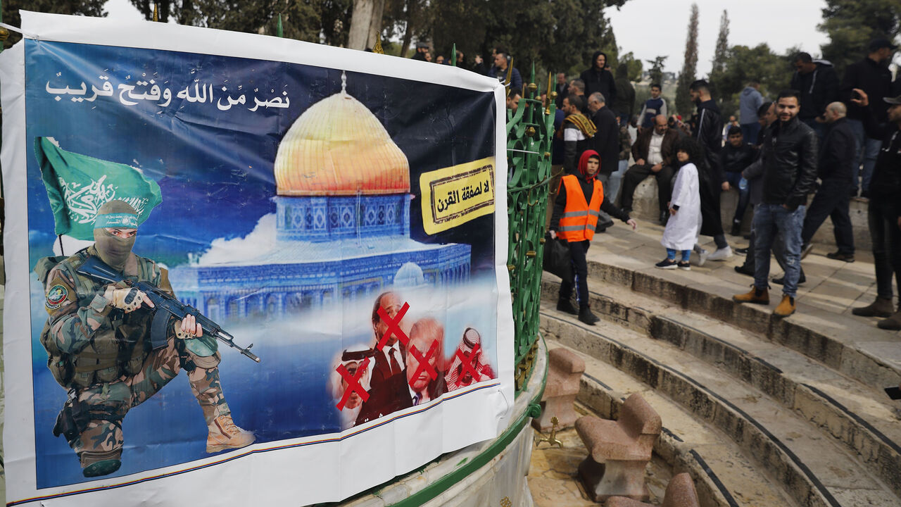 1200753858 A banner placed by Hamas with a slogan reading in Arabic: " no to the deal of the century" (US-prosed peace plan) is pictured as Palestinian Muslim worshippers gather at the Al-Aqsa mosque compound in the Old City of Jerusalem, on February 14, 2020. (Photo by Ahmad GHARABLI / AFP) (Photo by AHMAD GHARABLI/AFP via Getty Images)