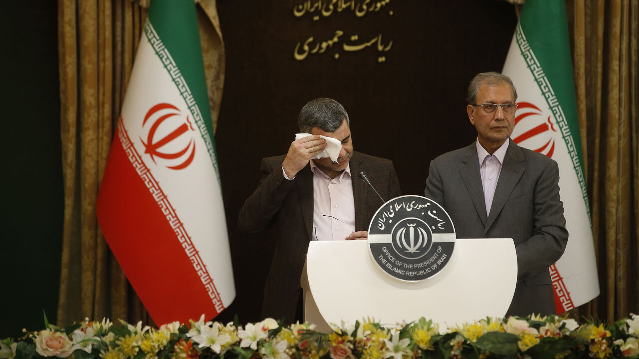 1203430949 Iranian Deputy Health Minister Iraj Harirchi (L) wipes the sweat off his face, during a press conference with the Islamic republic's government spokesman Ali Rabiei in the capital Tehran on February 24, 2020. - Iran's deputy health minister confirmed on February 25, that he has tested positive for the novel coronavirus, amid a major outbreak in the Islamic republic. Harirchi coughed occasionally and appeared to be sweating during the press conference with Rabiei in Tehran. (Photo by Mehdi BOLOURIAN / FARS N