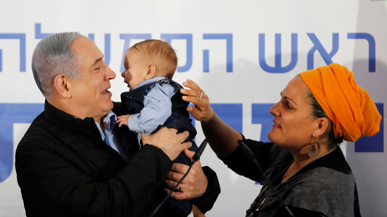 ISRAEL-PALESTINIANS/NETANYAHU Israeli Prime Minister Benjamin Netanyahu holds a baby during an event marking Tu BiShvat, the Jewish Arbor Day, in the Israeli settlement of Mevo'ot Yericho, in the Israeli-occupied West Bank February 10, 2020. REUTERS/Nir Elias - RC2RXE94OAAK