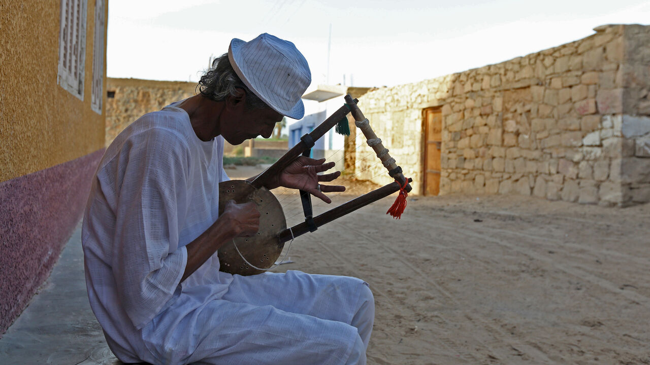 EGYPT-ELECTION/NUBIANS A man plays music on a traditional musical instrument in the Nubian village of Adindan near Aswan, south of Egypt, September 30, 2015. For half a century, Egypt's Nubians have patiently lobbied the government in Cairo for a return to their homelands on the banks of the Nile, desperate to reclaim territory their ancestors first cultivated 3,000 years ago. Yet all their efforts to gain political influence have brought next to nothing. In Egypt's incoming parliament, which will be finalised after a second rou