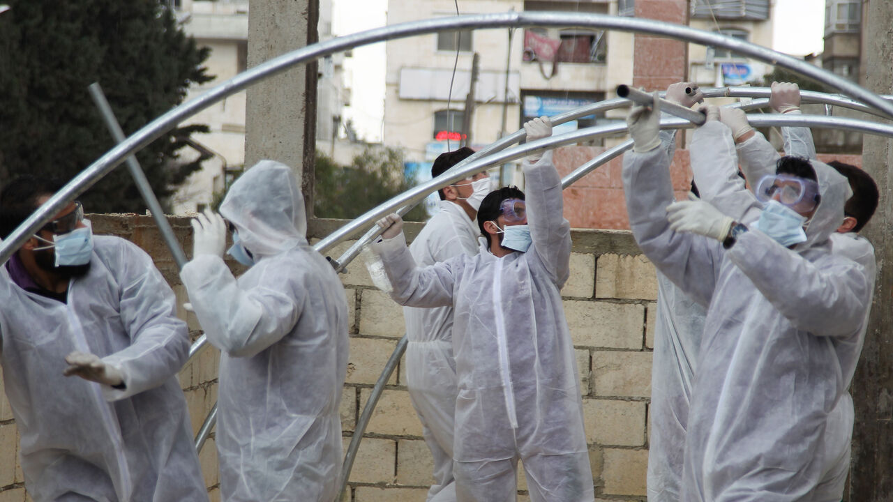 SYRIA-HEALTH-VIRUS Members of the Syrian Violet NGO set up triage tents for suspected coronavirus patients outside the Ibn Sina Hospital in Syria's northwestern Idlib city on March 19, 2020. - Syrian authorities on March 13 announced measures aimed at preventing coronavirus from reaching the war-torn country, including school closures and a ban on smoking shisha in cafes, state media reported. (Photo by Abdulaziz KETAZ / AFP) (Photo by ABDULAZIZ KETAZ/AFP via Getty Images)