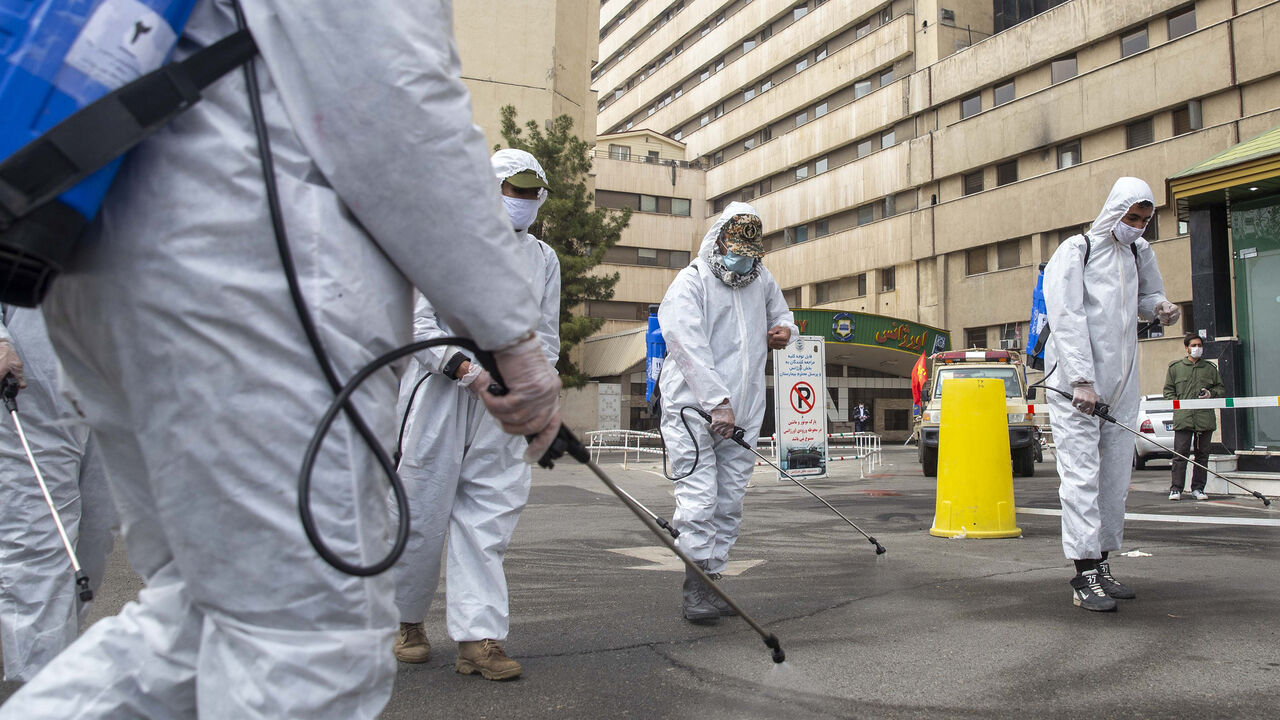 1208243114 TEHRAN, IRAN - MARCH 25: Irans revolutionary guard volunteer members disinfect the entrance of a hospital on March 25, 2020 in Tehran, Iran. Iran is battling the worst outbreak of coronavirus (COVID-19) in the region and authorities have advised people to stay at home but have not imposed the kinds of lockdowns seen in other countries. (Photo by Majid Saeedi/Getty Images)