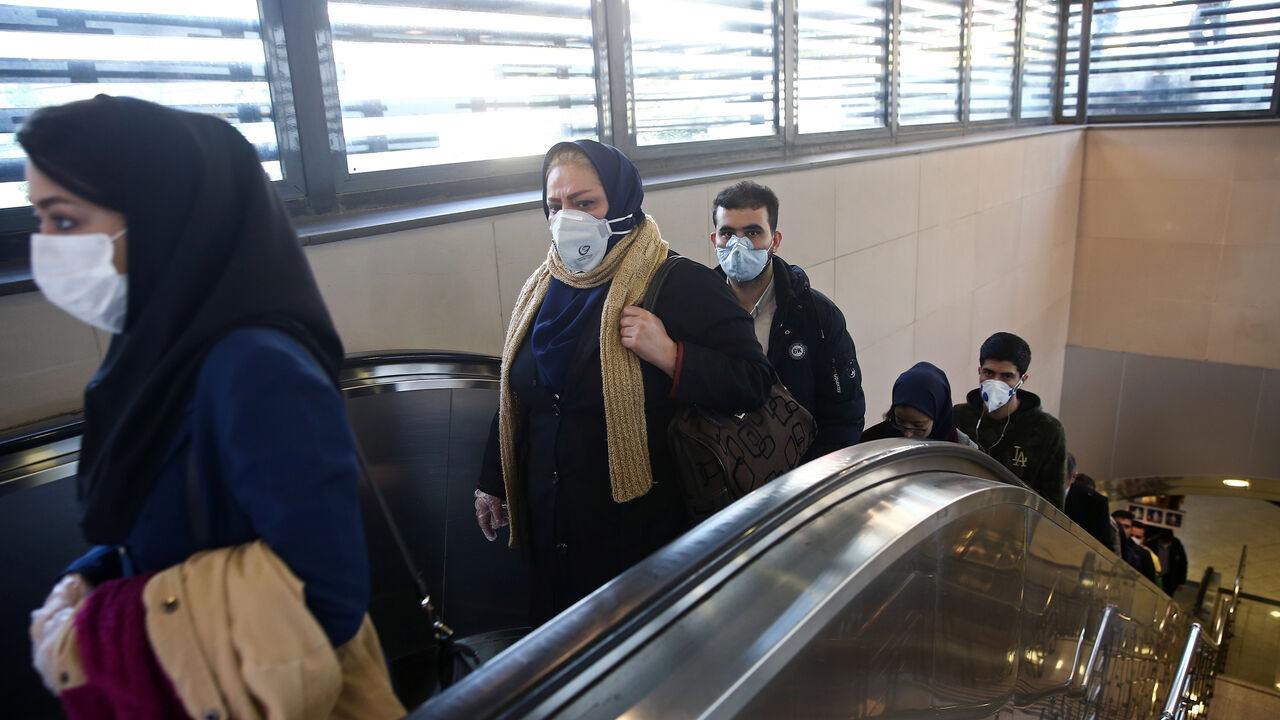 CHINA-HEALTH/IRAN Iranian people wear protective masks to prevent contracting a coronavirus, as they climb an escalator in Tehran, Iran February 29, 2020. WANA (West Asia News Agency)/Nazanin Tabatabaee via REUTERS ATTENTION EDITORS - THIS PICTURE WAS PROVIDED BY A THIRD PARTY - RC2BAF97VRQP