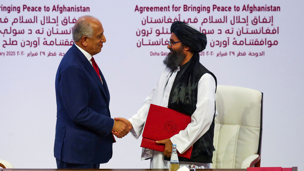 USA-AFGHANISTAN/TALIBAN-TRUMP Mullah Abdul Ghani Baradar, the leader of the Taliban delegation, and Zalmay Khalilzad, U.S. envoy for peace in Afghanistan, shake hands after signing an agreement at a ceremony between members of Afghanistan's Taliban and the U.S. in Doha, Qatar February 29, 2020. REUTERS/Ibraheem al Omari - RC2LAF91DVTE