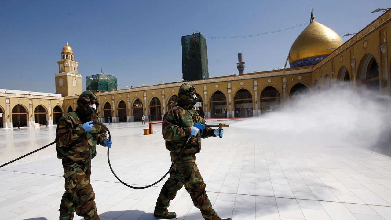 HEALTH-CORONAVIRUS/IRAQ-PILGRIMAGE Members of the civil defense team spray disinfectant to sanitize surrounding of the Kufa mosque, following an outbreak of the coronavirus, in the holy city of Najaf, Iraq February 27, 2020. Picture taken February 27, 2020. REUTERS/Alaa al-Marjani - RC2RDF9QBKYW