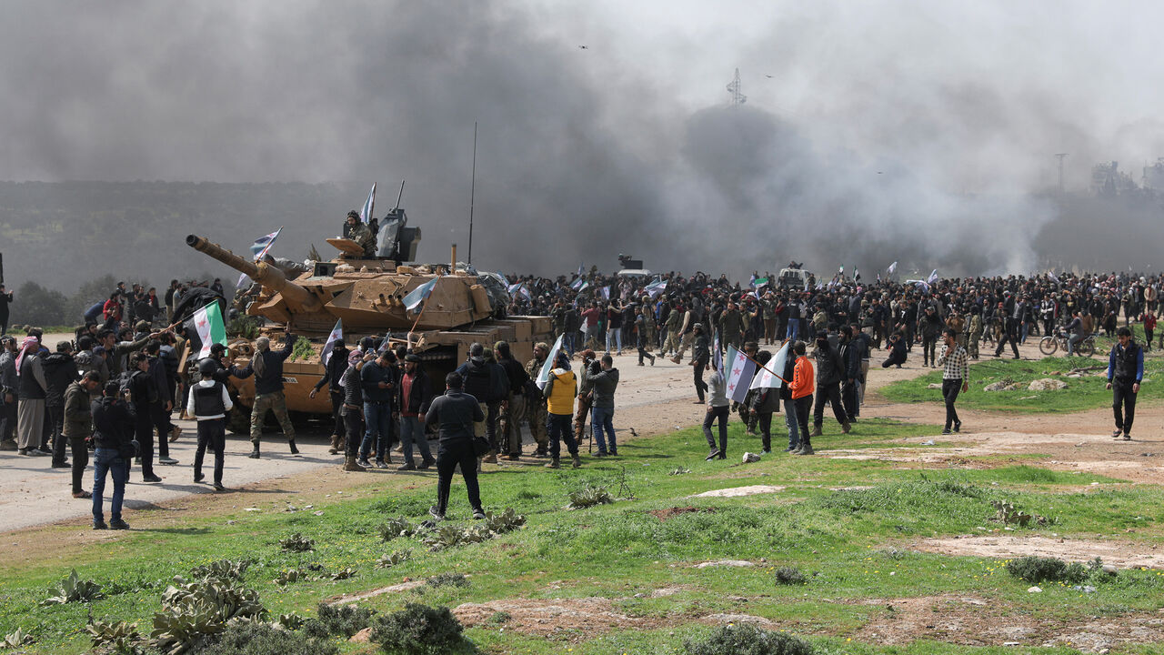 SYRIA-SECURITY/TURKEY-RUSSIA People hold Syrian opposition flags during a protest against an agreement on joint Russian and Turkish patrols, at M4 highway in Idlib province, Syria, March 15, 2020. REUTERS/Khalil Ashawi - RC2EKF9A7CNX