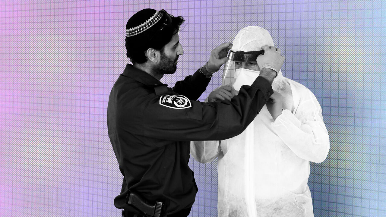 HEALTH-CORONAVIRUS/ISRAEL-PATROL An Israeli police officer helps a Health Ministry inspector put on protective gear before they go up to the apartment of a person in self quarantine as a precaution against coronavirus spread in Hadera, Israel March 16, 2020 REUTERS/Ronen Zvulun - RC23LF9W400M