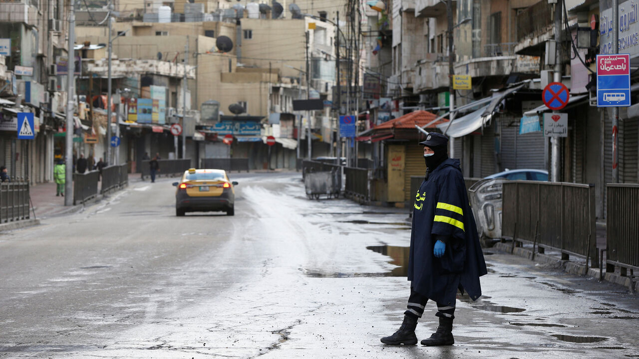 HEALTH-CORONAVIRUS/JORDAN A traffic police officer wearing a protective face mask stands on the street as the country takes measures to fight the spread of the coronavirus disease (COVID-19), in Amman, Jordan, March 18, 2020. REUTERS/Muhammad Hamed - RC2FMF9PF9CO