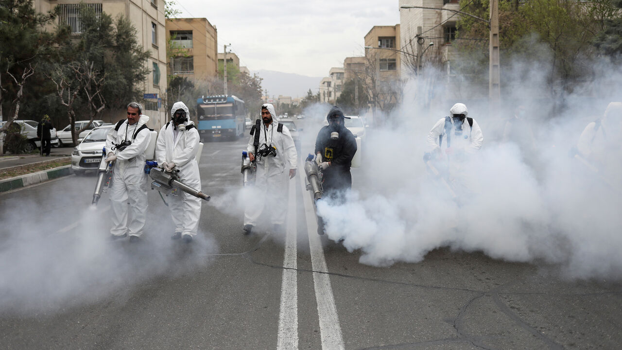HEALTH-CORONAVIRUS/IRAN-NOWRUZ Members of firefighters wear protective face masks, amid fear of coronavirus disease (COVID-19), as they disinfect the streets, ahead of the Iranian New Year Nowruz, March 20, in Tehran, Iran March 18, 2020. Picture taken March 18, 2020. WANA (West Asia News Agency)/Ali Khara via REUTERS ATTENTION EDITORS - THIS PICTURE WAS PROVIDED BY A THIRD PARTY TPX IMAGES OF THE DAY - RC23NF9FQH2G