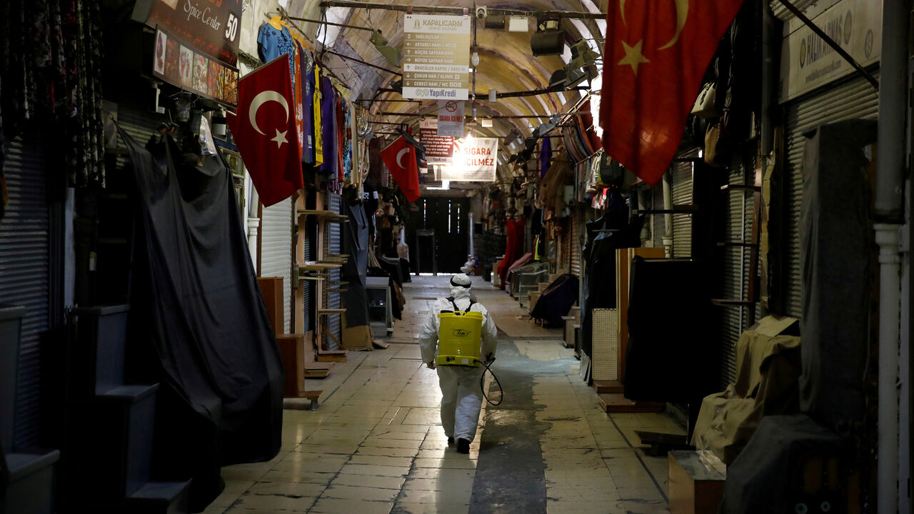 HEALTH-CORONAVIRUS/TURKEY A worker in a protective suit sprays disinfectant at Grand Bazaar, known as the Covered Bazaar, to prevent the spread of coronavirus disease (COVID-19), in Istanbul, Turkey, March 25, 2020. REUTERS/Umit Bektas TPX IMAGES OF THE DAY - RC2YQF9U548J