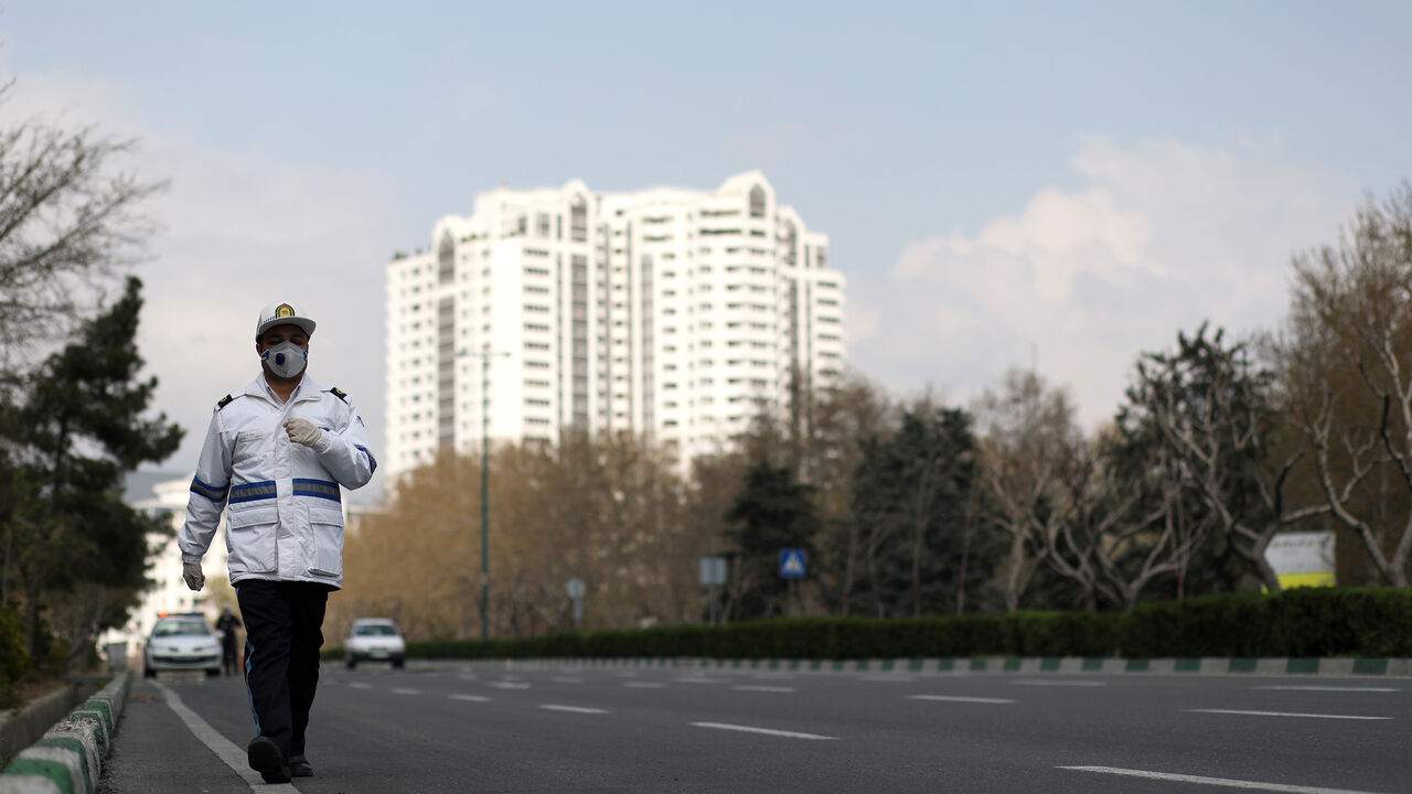 HEALTH-CORONAVIRUS/IRAN A traffic police officer wears a protective face mask and gloves, amid fear of coronavirus disease (COVID-19), as he walks in Tehran, Iran March 26, 2020. WANA (West Asia News Agency)/Ali Khara via REUTERS ATTENTION EDITORS - THIS PICTURE WAS PROVIDED BY A THIRD PARTY - RC2PRF9GFZAQ