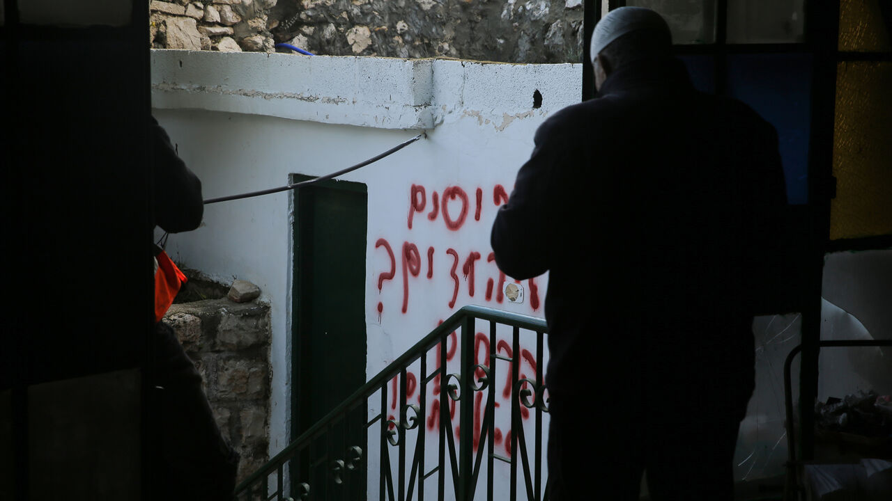 1195644743 JERUSALEM - JANUARY 24 : A view of Hebrew racial slurs on the wall of the mosque sprayed by Jewish settlers as eyewitnesses reported that a group of settlers set fire to the Badriya mosque in Beit Safafa town in Jerusalem on January 24, 2020. (Photo by Mostafa Alkharouf/Anadolu Agency via Getty Images)
