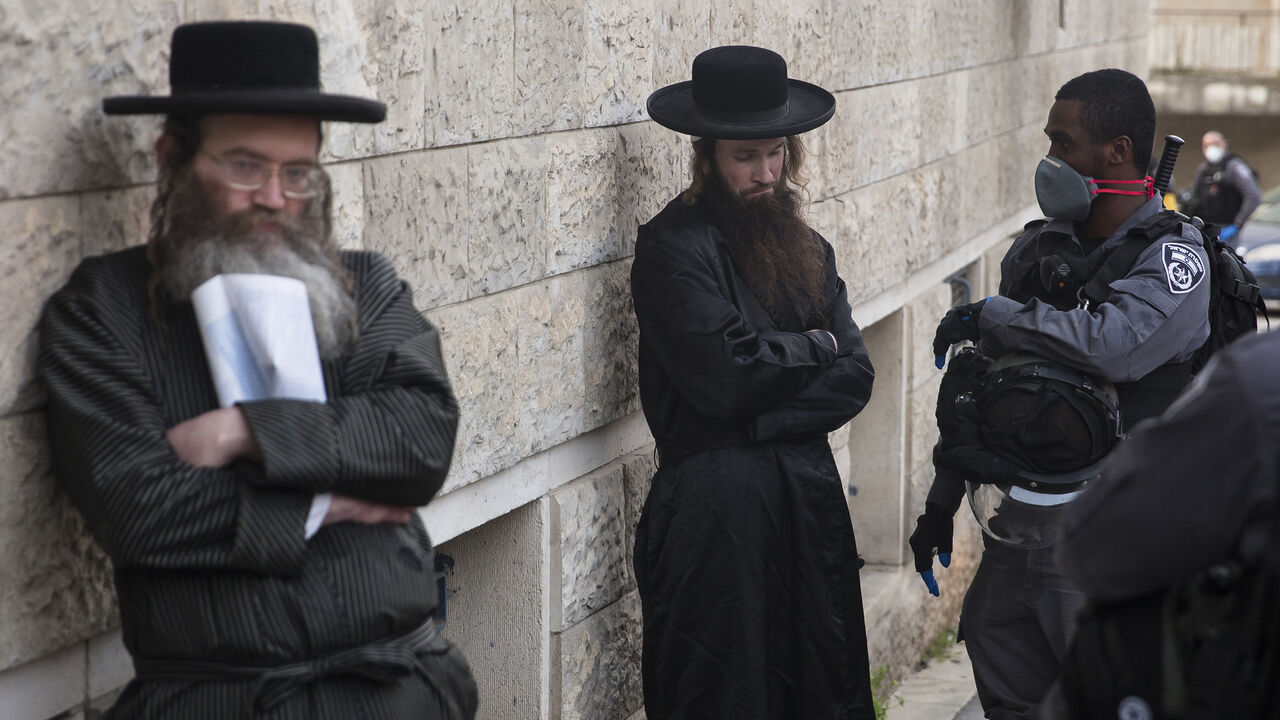 1208729806 JERUSALEM, ISRAEL - MARCH 31: Israeli police troops detain an Ultra Orthodox Jewish man as they enforce a partial Coronavirus lockdown in the Mea Shearim nighborhood on March 31, 2020 in Jerusalem, Israel. The Coronavirus (COVID-19) pandemic has spread to many countries across the world, claiming over 30,000 lives and infecting hundreds of thousands more. (Photo by Amir Levy/Getty Images)