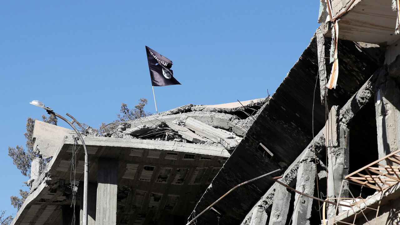 MIDEAST-CRISIS/SYRIA-RAQQA A flag of Islamic State militants is pictured above a destroyed house near the Clock Square in Raqqa, Syria October 18, 2017. Picture taken October 18, 2017. REUTERS/Erik De Castro - RC159E696010