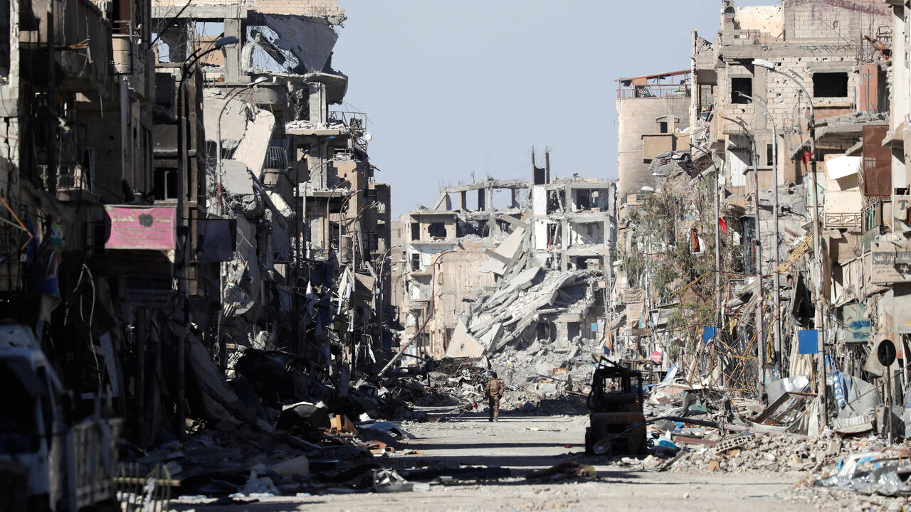 MIDEAST-CRISIS/SYRIA-RAQQA A fighter of Syrian Democratic Forces stands amidst the ruins of buildings near the Clock Square in Raqqa, Syria October 18, 2017. Picture taken October 18, 2017. REUTERS/Erik De Castro - RC1E4E003870