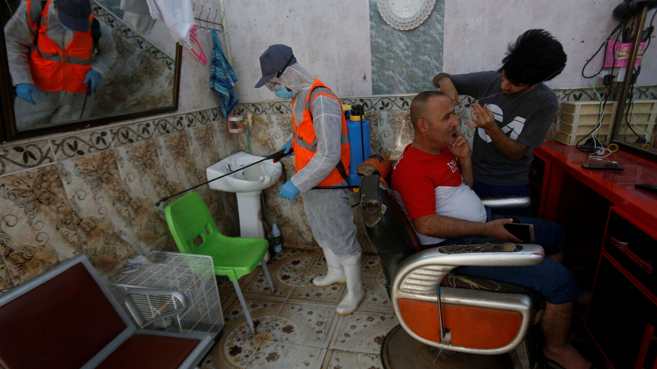 HEALTH-CORONAVIRUS/IRAQ-BASRA A worker in protective suit sprays disinfectants in a barber shop at popular market, following an outbreak of the coronavirus, in Basra, Iraq March 10, 2020. REUTERS/Essam al-Sudani - RC24HF95V7S1