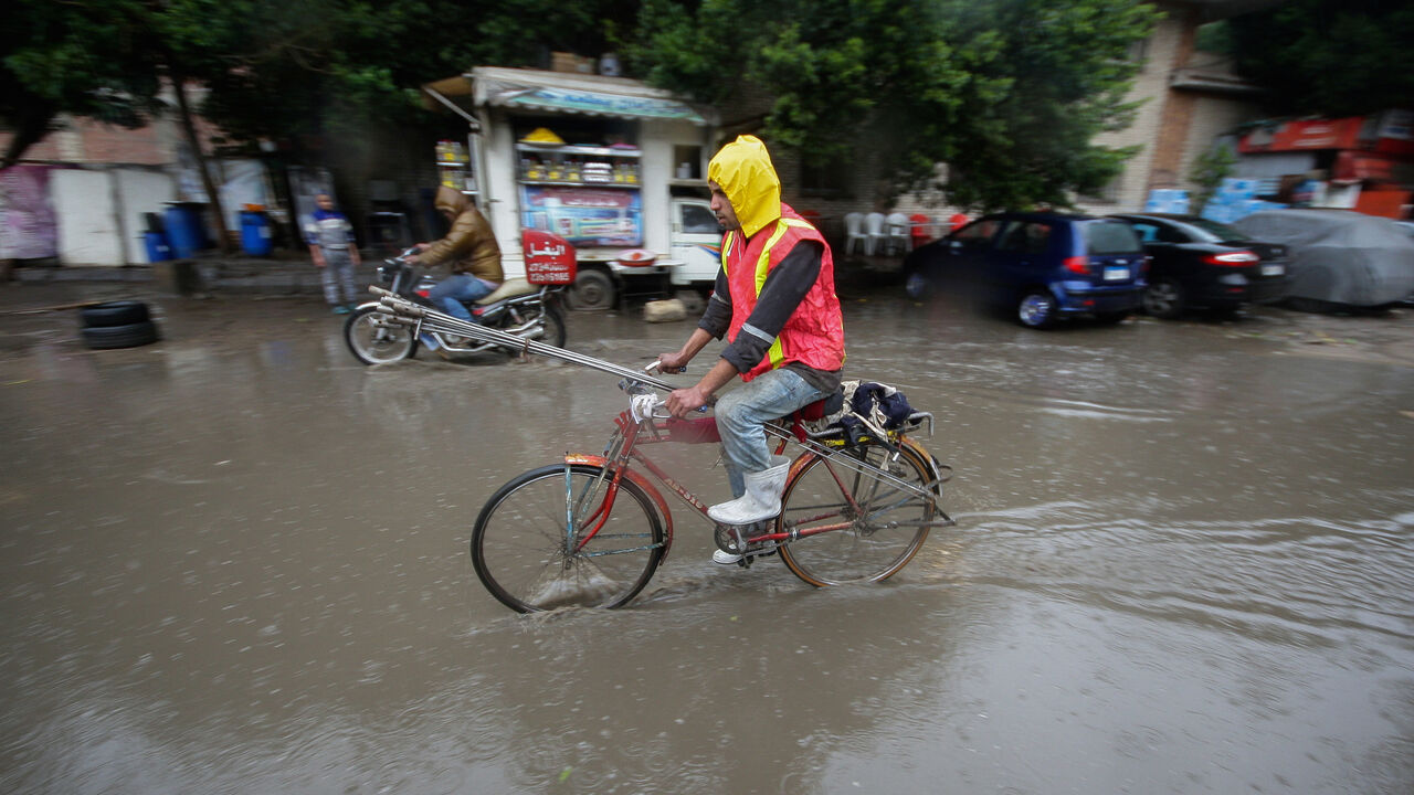 EGYPT-WEATHER/ A man rides a bicycle during a thunderstorm and heavy rains in downtown of Cairo, as the government announced a day off while the rain exceeds the infrastructure's capacity in most cities in Egypt March 12, 2020. REUTERS/Shokry Hussien - RC2BIF9XYLHI